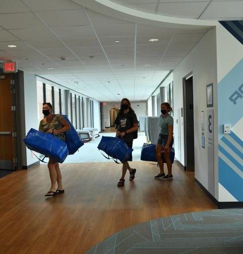 Two students moving into dorm room